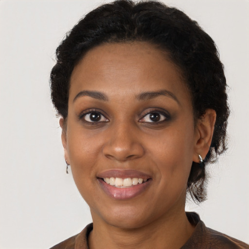 Joyful black young-adult female with short  brown hair and brown eyes