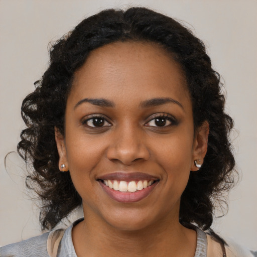 Joyful black young-adult female with medium  black hair and brown eyes