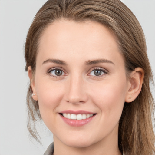 Joyful white young-adult female with long  brown hair and grey eyes