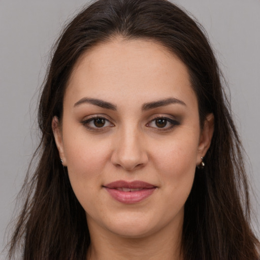 Joyful white young-adult female with long  brown hair and brown eyes