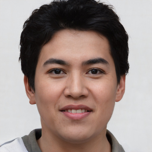 Joyful asian young-adult male with short  black hair and brown eyes