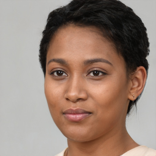Joyful black young-adult female with short  black hair and brown eyes