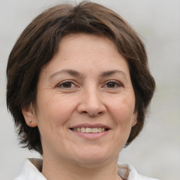 Joyful white adult female with medium  brown hair and brown eyes