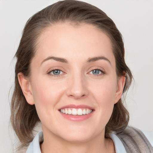 Joyful white young-adult female with medium  brown hair and blue eyes