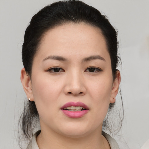 Joyful asian young-adult female with medium  brown hair and brown eyes