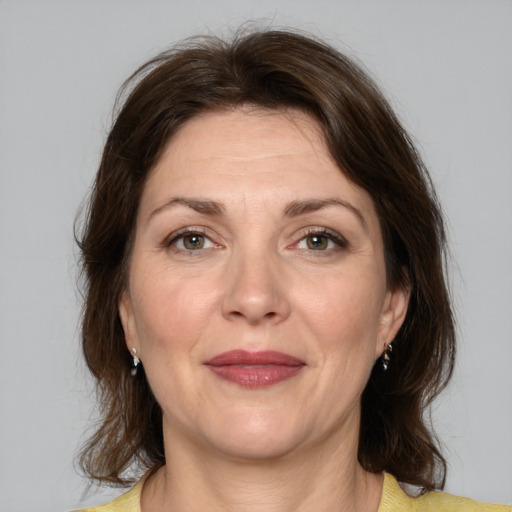 Joyful white adult female with medium  brown hair and grey eyes