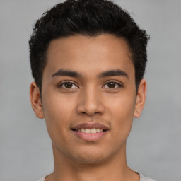 Joyful latino young-adult male with short  brown hair and brown eyes