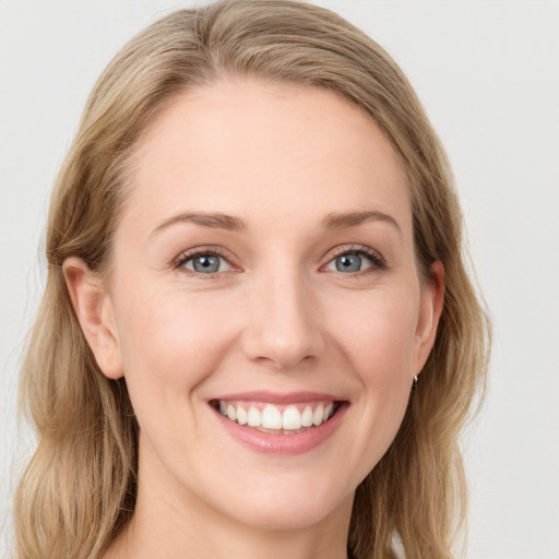 Joyful white young-adult female with long  brown hair and blue eyes