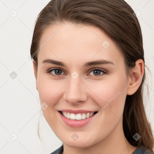 Joyful white young-adult female with long  brown hair and grey eyes