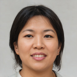 Joyful asian young-adult female with medium  brown hair and brown eyes