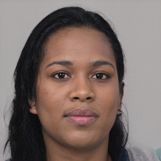 Joyful black young-adult female with long  black hair and brown eyes