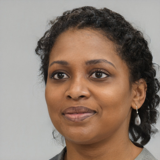 Joyful black young-adult female with medium  black hair and brown eyes