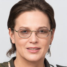 Joyful white adult female with medium  brown hair and grey eyes