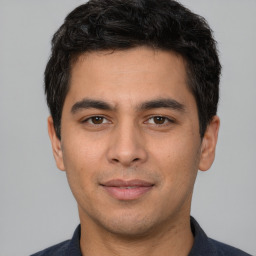 Joyful white young-adult male with short  black hair and brown eyes