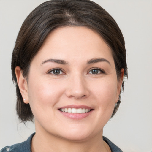 Joyful white young-adult female with medium  brown hair and brown eyes