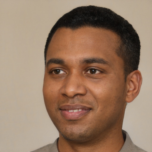 Joyful black young-adult male with short  black hair and brown eyes