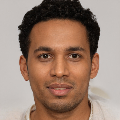 Joyful latino young-adult male with short  brown hair and brown eyes