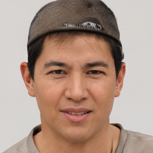 Joyful asian adult male with short  brown hair and brown eyes