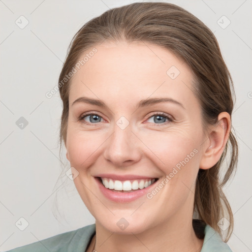 Joyful white young-adult female with medium  brown hair and grey eyes