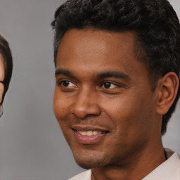 Joyful black young-adult male with short  black hair and brown eyes