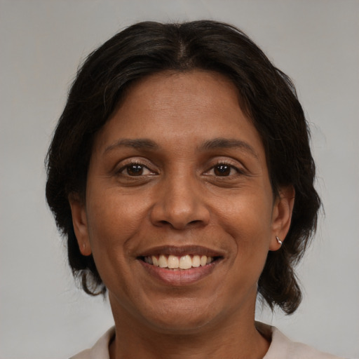 Joyful black adult female with medium  brown hair and brown eyes