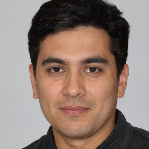 Joyful white young-adult male with short  black hair and brown eyes