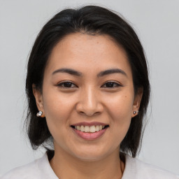 Joyful asian young-adult female with medium  brown hair and brown eyes