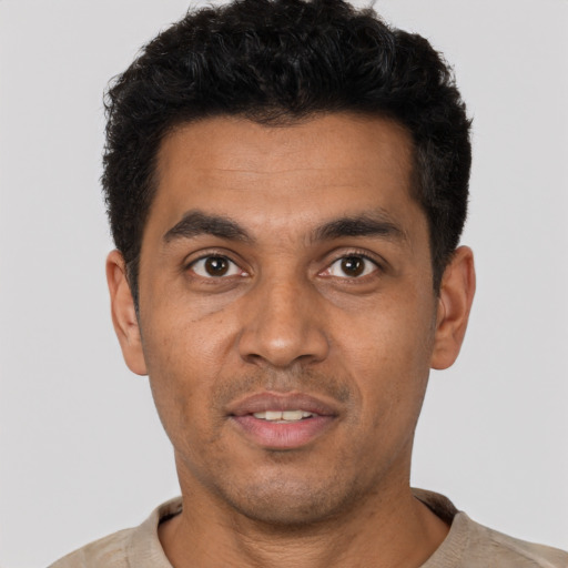 Joyful latino young-adult male with short  black hair and brown eyes