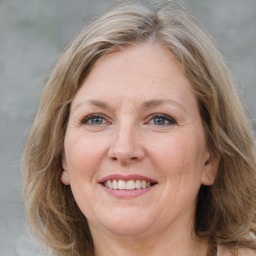 Joyful white adult female with medium  brown hair and grey eyes