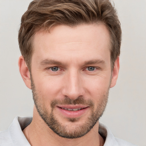 Joyful white young-adult male with short  brown hair and grey eyes