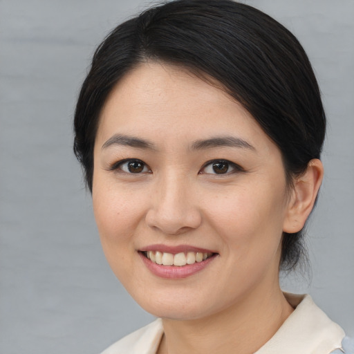 Joyful asian young-adult female with medium  brown hair and brown eyes