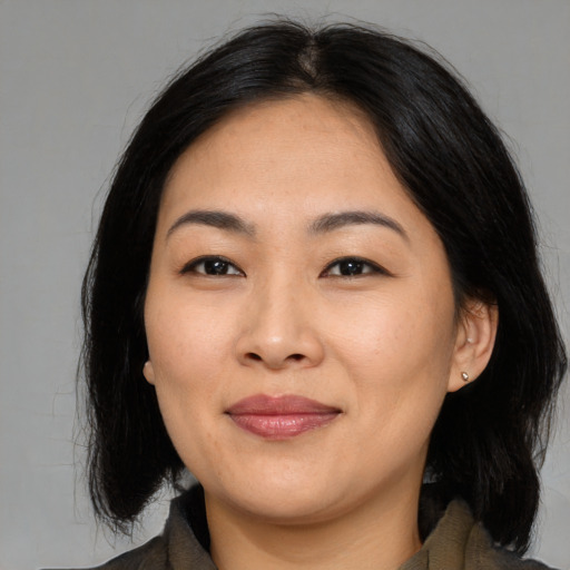 Joyful asian young-adult female with medium  brown hair and brown eyes