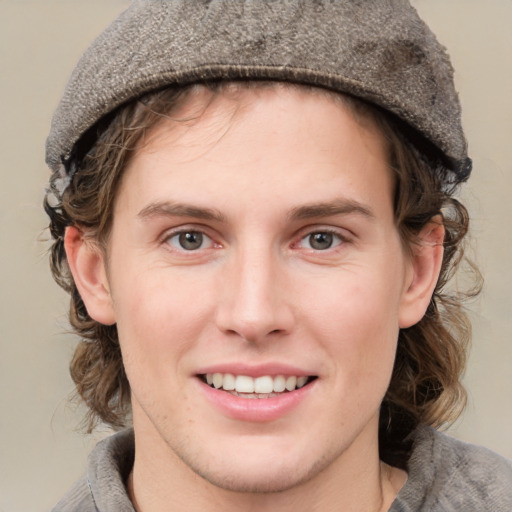 Joyful white young-adult male with medium  brown hair and grey eyes