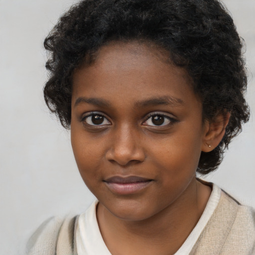 Joyful black child female with short  brown hair and brown eyes