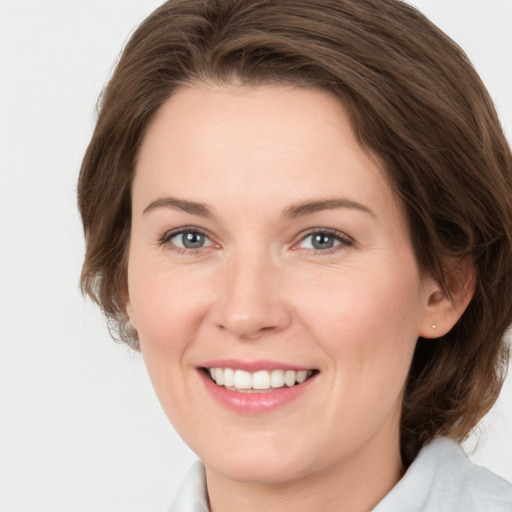 Joyful white young-adult female with medium  brown hair and green eyes