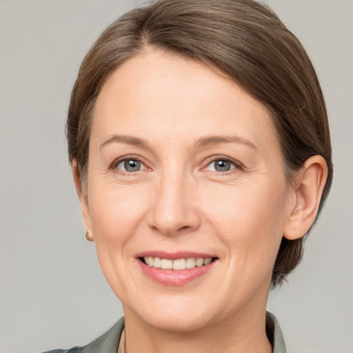 Joyful white adult female with short  brown hair and grey eyes