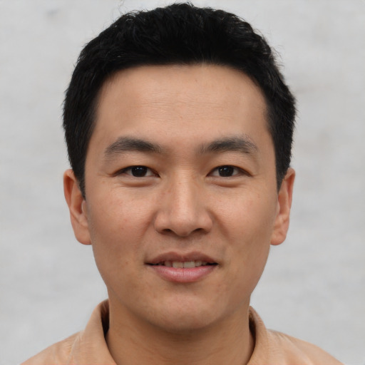 Joyful asian young-adult male with short  black hair and brown eyes