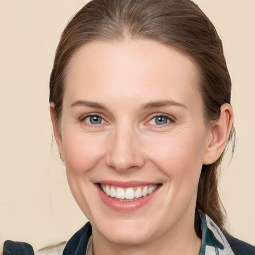 Joyful white young-adult female with medium  brown hair and grey eyes