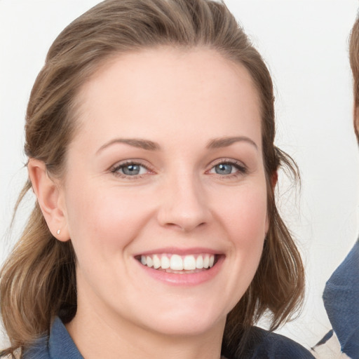 Joyful white young-adult female with medium  brown hair and blue eyes