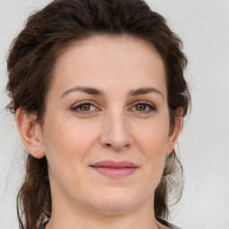 Joyful white young-adult female with long  brown hair and green eyes