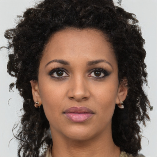 Joyful black young-adult female with long  brown hair and brown eyes