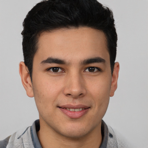 Joyful latino young-adult male with short  brown hair and brown eyes