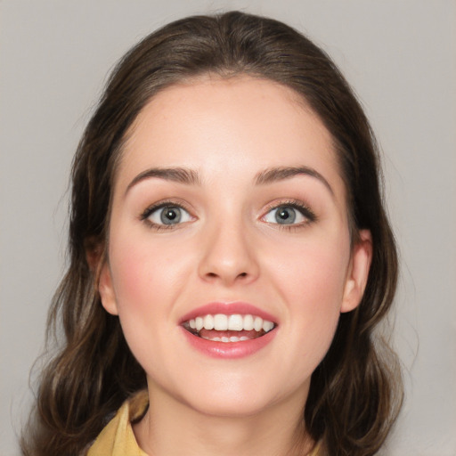 Joyful white young-adult female with medium  brown hair and grey eyes