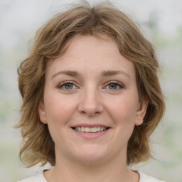 Joyful white young-adult female with medium  brown hair and green eyes