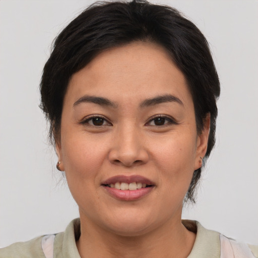 Joyful asian young-adult female with short  brown hair and brown eyes