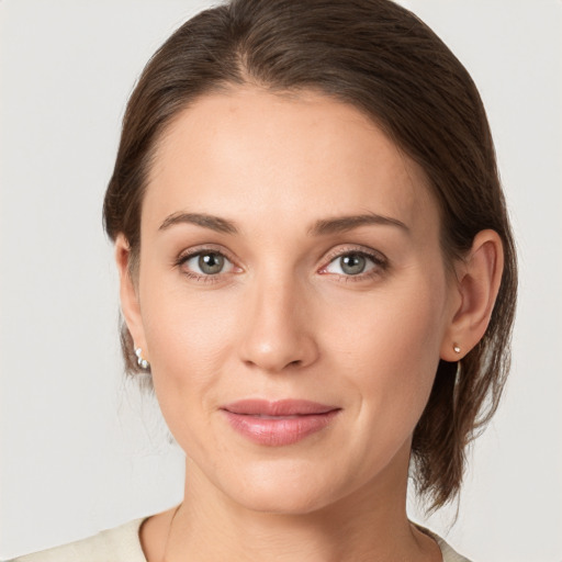 Joyful white young-adult female with medium  brown hair and grey eyes