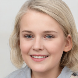 Joyful white young-adult female with medium  brown hair and blue eyes