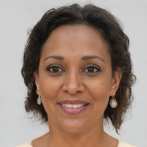 Joyful black adult female with medium  brown hair and brown eyes
