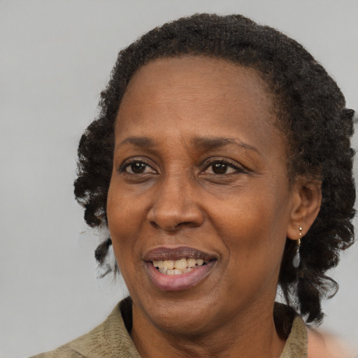 Joyful black adult female with medium  brown hair and brown eyes