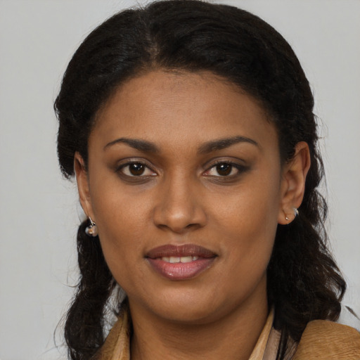 Joyful black young-adult female with long  brown hair and brown eyes